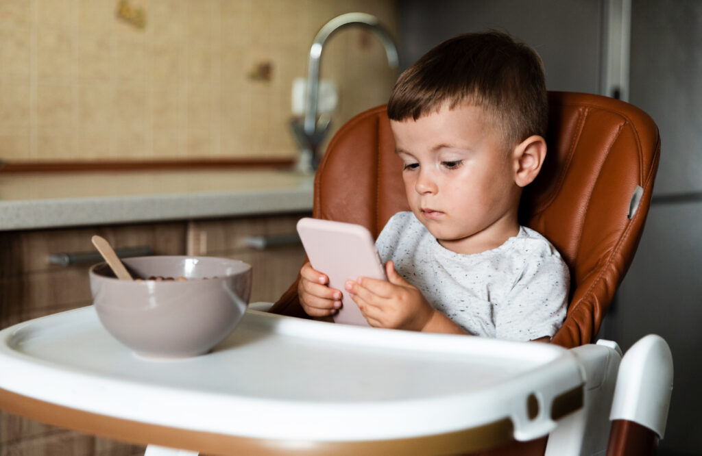 Kid using phone while etating