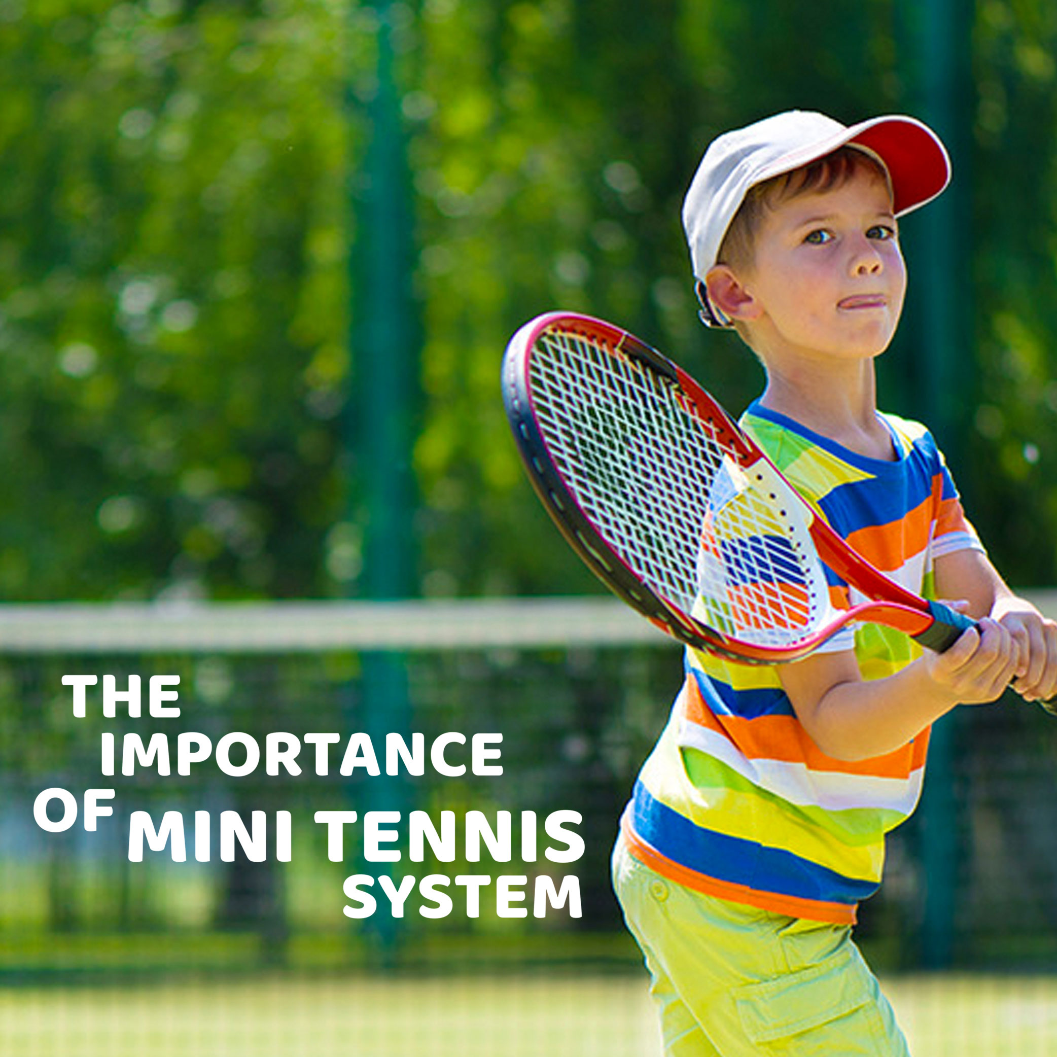 A toddler using a small, lightweight red racket to hit a soft oversized tennis ball over a low net.